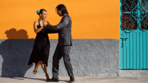Pareja de mujer y hombre bailando tango en una calle de Buenos Aires. 