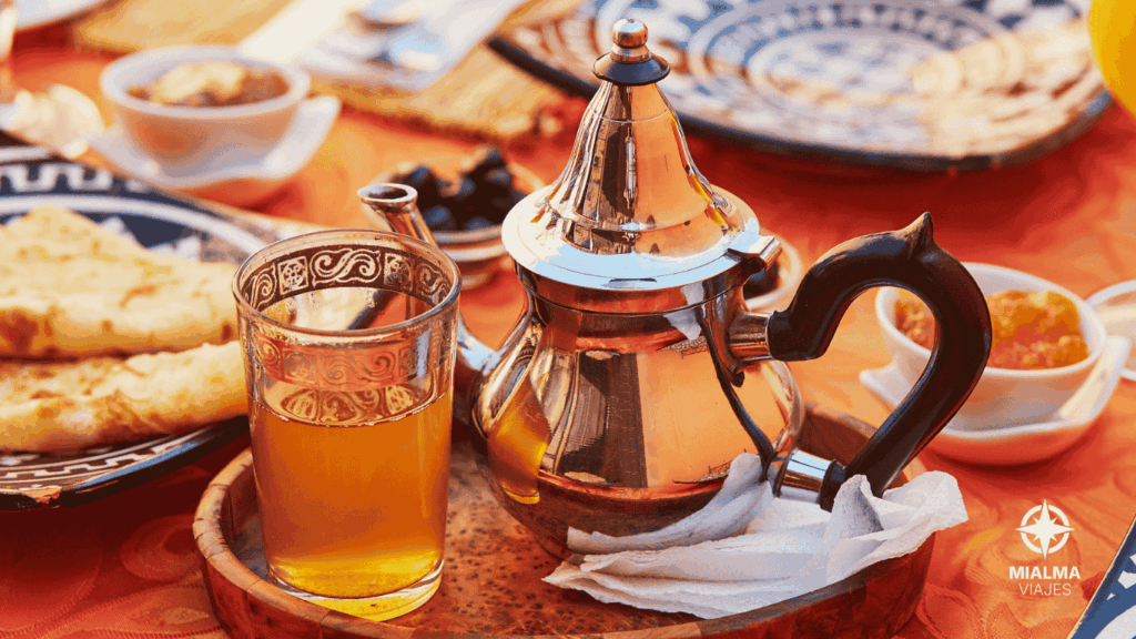 Desayuno típico marroquí, con tetera y vaso con té y dulces típicos marroquís